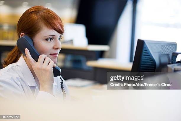 female receptionist talking on phone - sekretärin stock-fotos und bilder