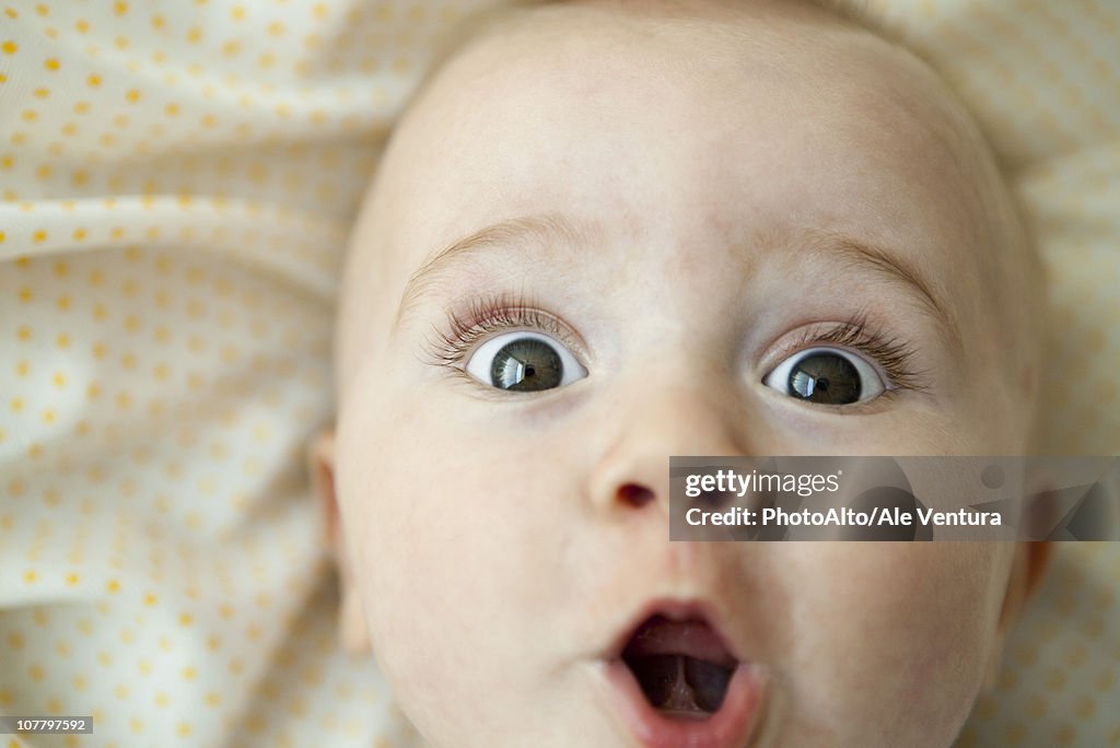 Baby looking at camera with surprised expression, portrait