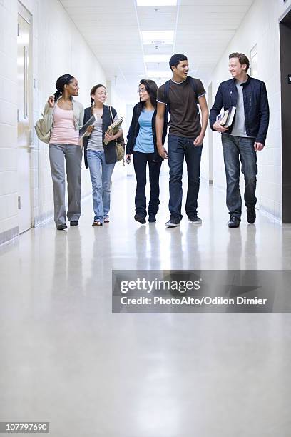 high school students walking down school corridor - male student wearing glasses with friends stockfoto's en -beelden