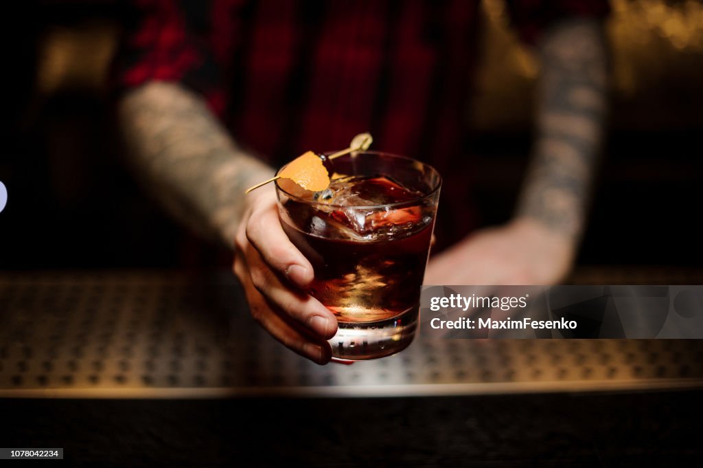 Professionele barman serveert een heerlijke Godfather cocktail