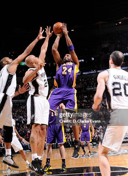 Kobe Bryant of the Los Angeles Lakers shoots against Tim Duncan and Richard Jefferson of the San Antonio Spurs during the game on December 28, 2010...