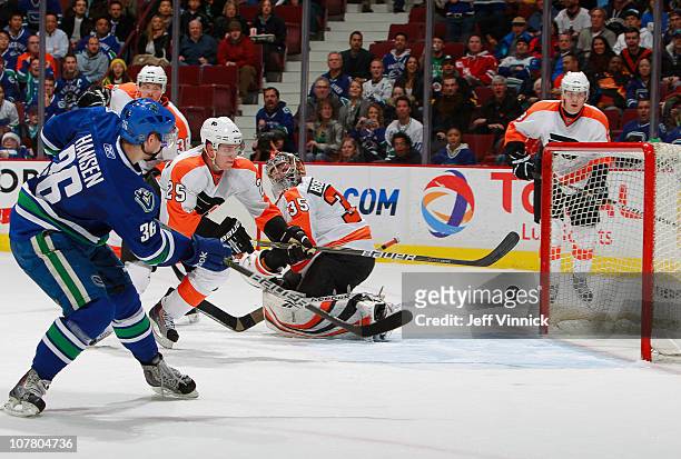 Matt Carle of the Philadelphia Flyers looks on as Jannik Hansen of the Vancouver Canucks shoots the puck past Sergei Bobrovsky of the Philadelphia...