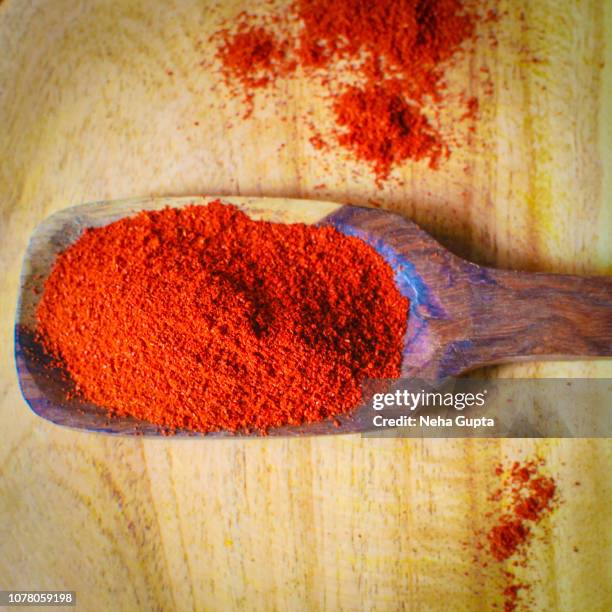 red chilli powder - wooden spoon - chilli powder stock-fotos und bilder