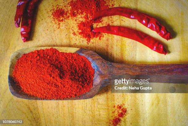 red chilli powder - wooden spoon - chilli powder stock-fotos und bilder