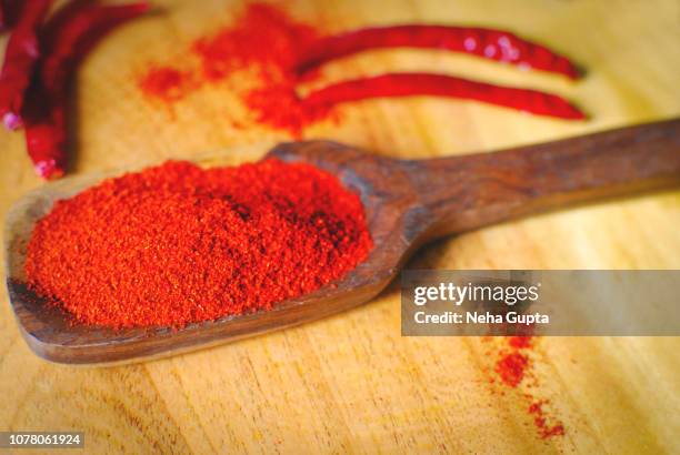 red chilli powder - wooden spoon - chilli powder stock-fotos und bilder