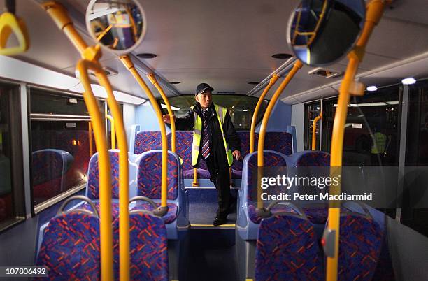 Night bus driver Chitpinit Kaewchaluay checks his bus at Cricklewood Bus Depot on December 15, 2010 in London, England. Chitpinit will drive the...
