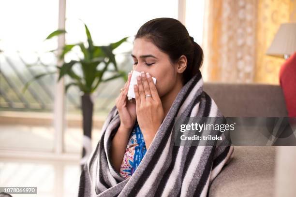 生病的女人吹她的鼻子 - 病毒感染 個照片及圖片檔