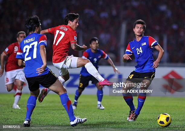 Indonesia's striker Irfan Bachdim challenges Malaysia's players Mochamad Muslim and Mochamad Fadli during their second leg final of the AFF Suzuki...