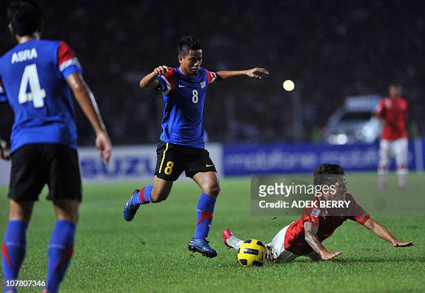 Indonesia's striker Irfan Bachdim falls next to Malasyia's player Safiq Rahim during their second leg final of the AFF Suzuki Cup 2010, on December...