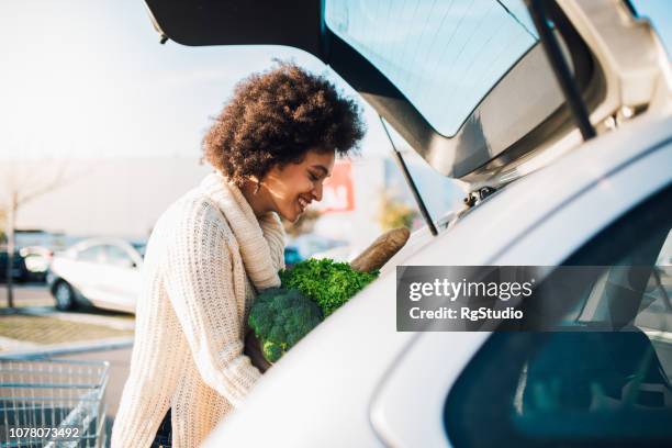 alimenticios de embalaje chica feliz - car trunk fotografías e imágenes de stock