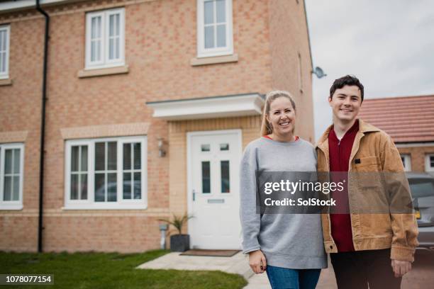 couple standing outside new home - lawn mover stock pictures, royalty-free photos & images