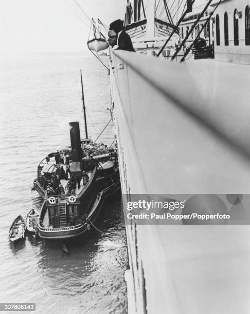 The White Star Line tender 'America' ferries mail to the 'Titanic' at Queenstown in Ireland, prior to her first and only voyage across the Atlantic,...