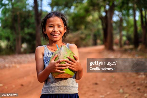 happy cambodian girl holding fresh coconut, cambodia - coconut water stock pictures, royalty-free photos & images