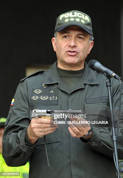 National Police Chief Gen. Oscar Naranjo, holds a handgun seized to Colombian drug lord and former paramilitary leader Pedro Guerrero Castillo, known...