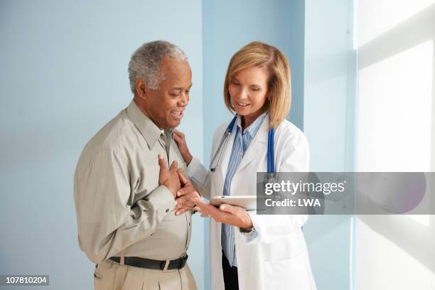 doctor giving senior patient test results - doctor giving good news stock pictures, royalty-free photos & images