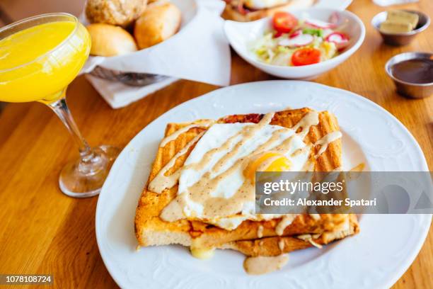brunch with croque madame and mimosa cocktail at the restaurant - croque monsieur stockfoto's en -beelden