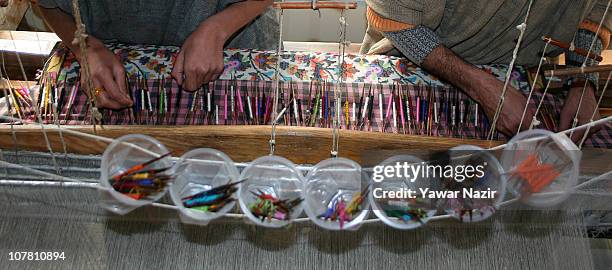 Kashmiri artisans work on a woven Kani, or Jamewar shawl, at their workshop on December 29, 2010 in the outskirts of Srinagar, the summer capital of...