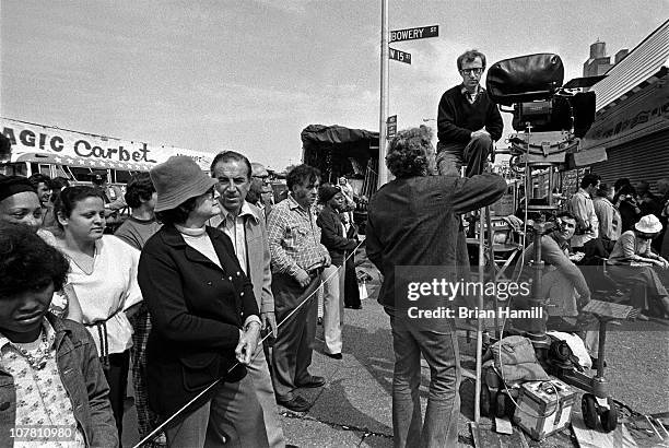 American film director and actor Woody Allen sits atop a ladder and talks with his crew during the filming his movie 'Annie Hall,' Coney Island, New...