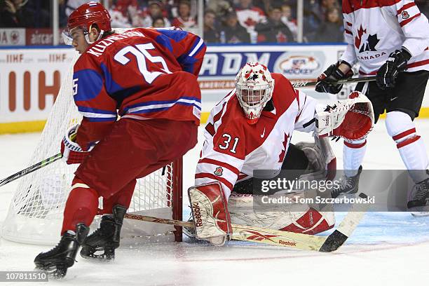 Goalie Olivier Roy of Canada and Yevgeni Kuznetsov of Russia during the 2011 IIHF World U20 Championship Group B game between Canada and Russia on...