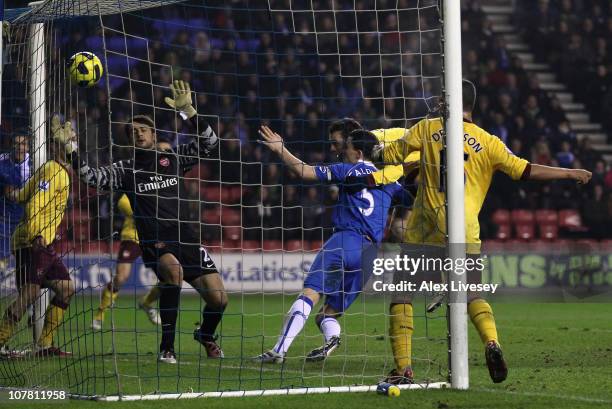 Sebastien Squillaci of Arsenal scores an own goal to level the scores during the Barclays Premier League match between Wigan Athletic and Arsenal at...