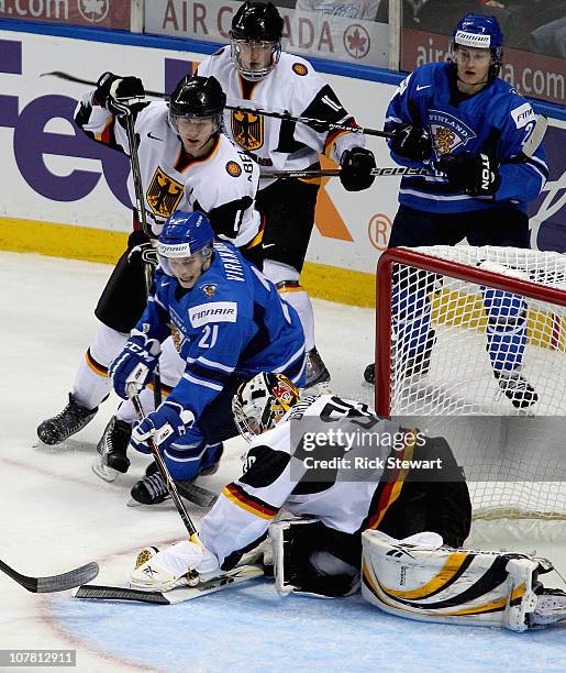 Philipp Grubauer of Germany covers the puck ahead of Valteri Virkkunen of Finland during the 2011 IIHF World U20 Championship game at the HSBC Arena...