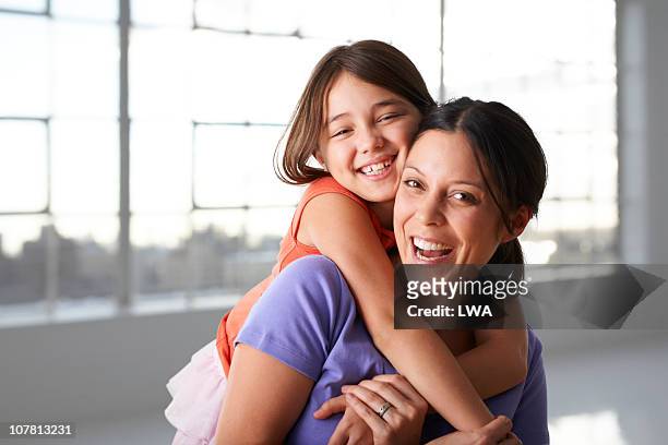happy girl hugging mother - hispanic mother child stock-fotos und bilder