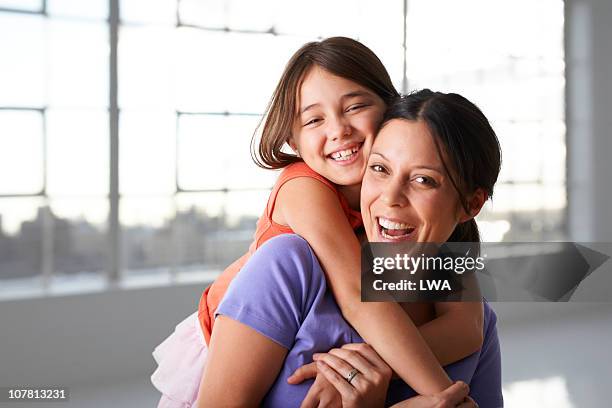 happy girl hugging mother - mujeres de mediana edad fotografías e imágenes de stock