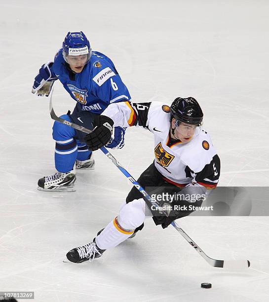 Benjamin Hufner of Germany skates away from Teemu Pulkkinen of Finland during the 2011 IIHF World U20 Championship game between Germany and Finland...