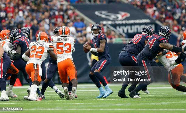 Deshaun Watson of the Houston Texans looks to pass under pressure by Myles Garrett of the Cleveland Browns an dJoe Schobert in the second half at NRG...