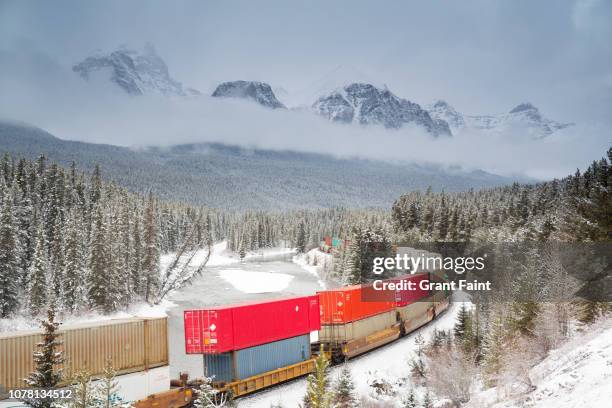 train moving through mountains. - boxcar stock-fotos und bilder