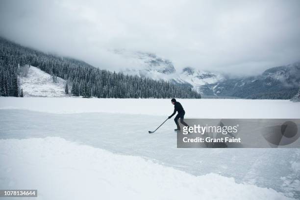 young man skating on frozen lake. - men's ice hockey stockfoto's en -beelden