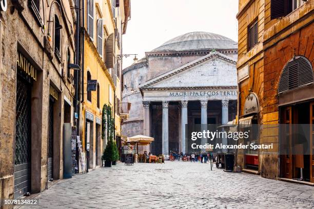 old cobblestone street in rome and pantheon in the center, italy - pantheon roma foto e immagini stock