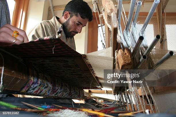 Kashmiri artisans work on a woven Kani, or Jamewar shawl, at their workshop December 29, 2010 on the outskirts of Srinagar, the summer capital of...