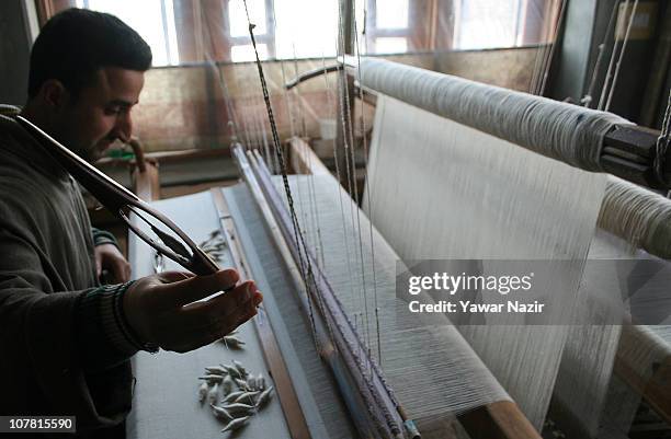 Kashmiri artisan works on a pashmina shawl with shuttle, at his workshop December 29, 2010 on the outskirts of Srinagar, the summer capital of Indian...