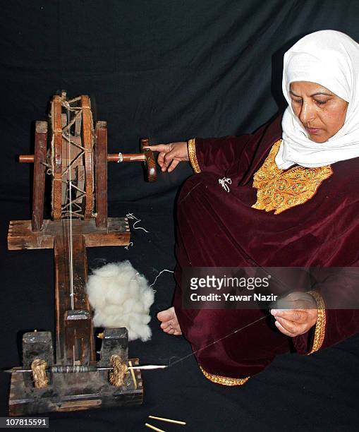 Kashmiri Muslim woman spins pashmina on a wheel used in shawl making December 29, 2010 in Srinagar, the summer capital of Indian administered...