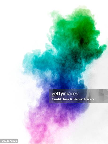 explosion by an impact of a cloud of particles of powder and smoke of color green and blue on a white background. - paint explosion stock pictures, royalty-free photos & images