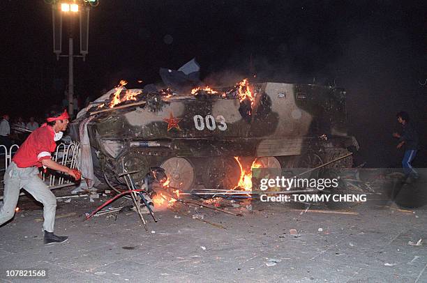 This file photo taken on June 4, 1989 shows an armoured personnel carrier in flames as students set it on fire near Tiananmen Square in Beijing....