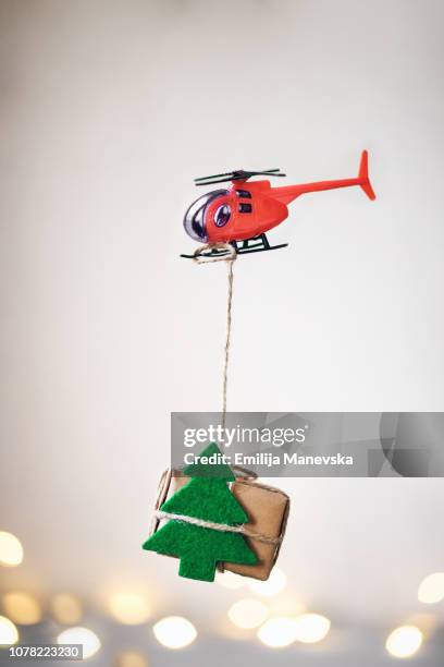 helicopter carrying a christmas gift - toy helicopter stock pictures, royalty-free photos & images