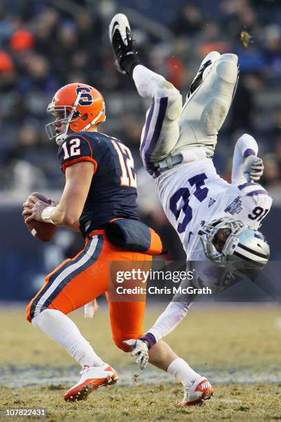 Quarterback Ryan Nassib of the Syracuse Orange gets around a diving tackle by Terrence Sweeney of the Kansas State Wildcats during the New Era...