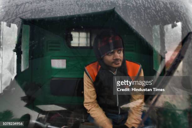 Driver seen inside a vehicle during light rainfall on a winter morning, at Okhla vegetable market, on January 6, 2019 in New Delhi, India. The...