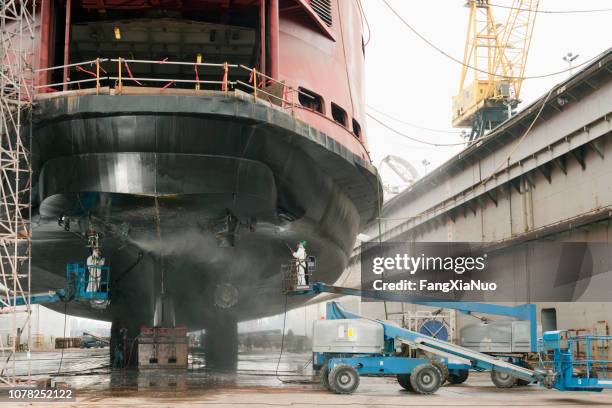 werknemers repareren veerboot schip in droogdok - scheepsbouwer stockfoto's en -beelden