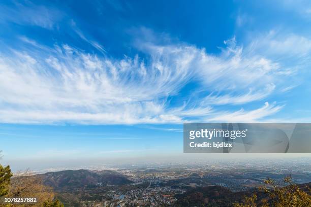 blauwe hemel en witte wolken over de stad - wind stockfoto's en -beelden