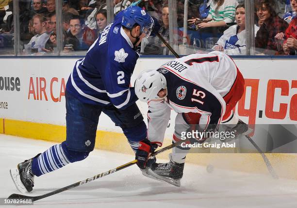 Luke Schenn of the Toronto Maple Leafs battles for the puck with Derek Dorsett of the Columbus Blue Jackets during game action December 30, 2010 at...