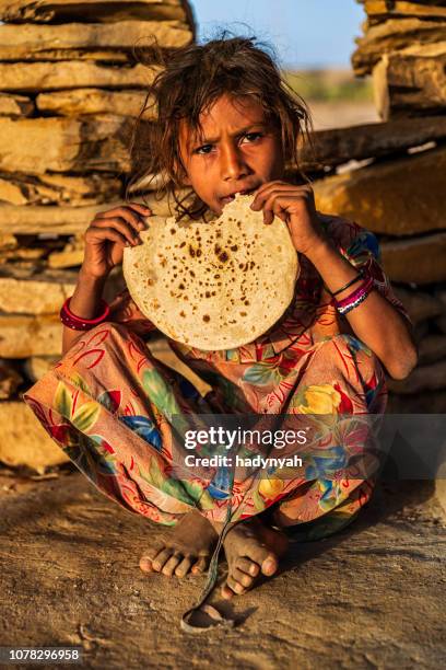 indian little girl eating chapatti, flat bread, desert village - hungry stock pictures, royalty-free photos & images