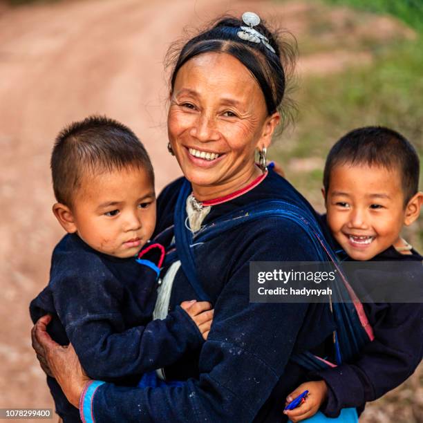 laotian mother walking with her children in a village in northern laos - laotian culture stock pictures, royalty-free photos & images