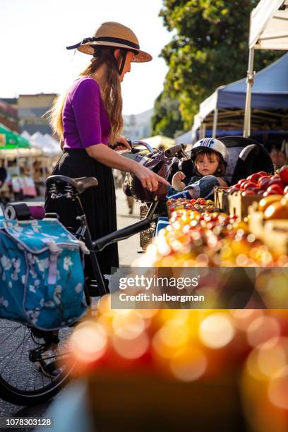 mutter und kleinkind auswahl tomaten auf bauernmarkt - shopping with bike stock-fotos und bilder