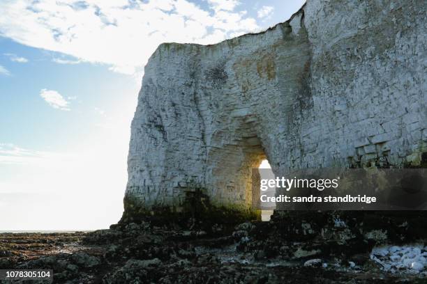 a stunning landscape view of a coastal bay at kingsgate, thanet, kent, uk. kingsgate castle can be seen through the arch in the chalk cliffs. - broadstairs stock-fotos und bilder