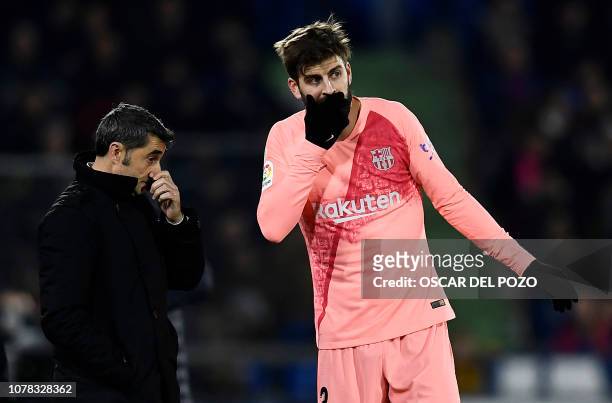 Barcelona's Spanish defender Gerard Pique speaks with Barcelona's Spanish coach Ernesto Valverde during the Spanish League football match between...