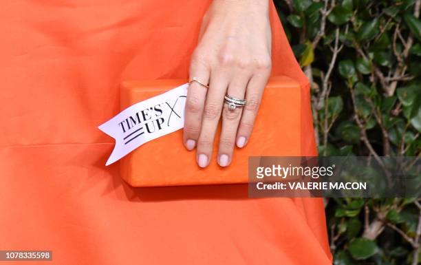 Actress D'Arcy Carden holds a tag reading "Time's Up" as she arrives for the 76th annual Golden Globe Awards on January 6 at the Beverly Hilton hotel...