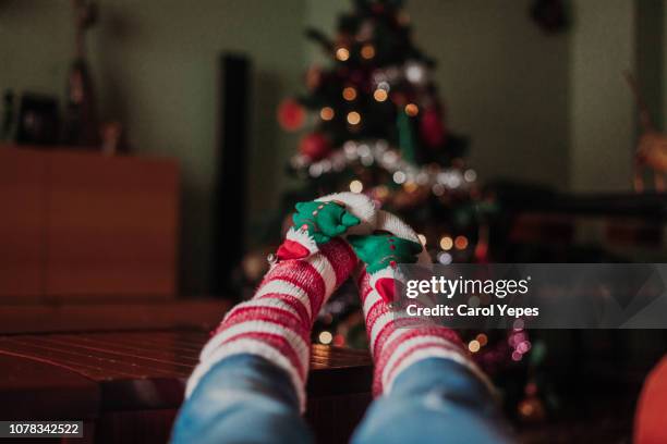 legs with xmas socks on table.blurred xmas tree on background - sock stock pictures, royalty-free photos & images